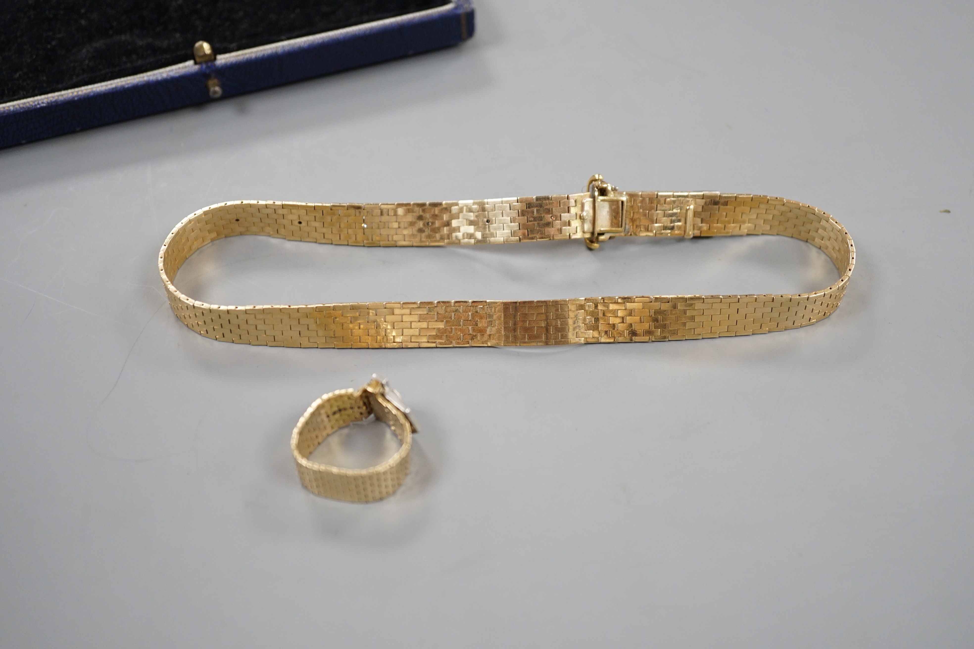 An unmarked yellow metal, ruby and diamond necklace, with 'buckle' clasp, 67cm and a matching ring, size U/V, gross weight 58.3 grams.